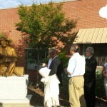 Alex Palkovich and others looking at the sculpture after it has been unveiled